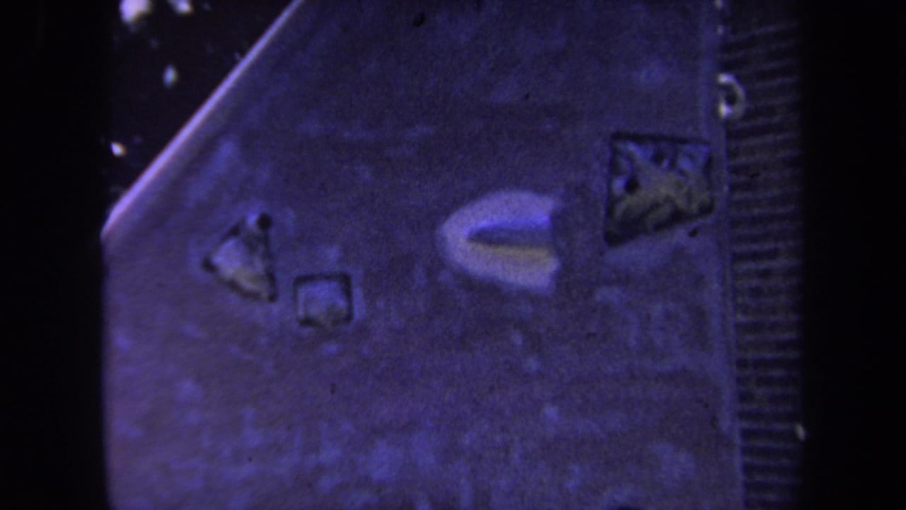 1969 Yucaipa 8mm frame showing a close, soft-focus view of a slanted wooden structure with small surface markings.