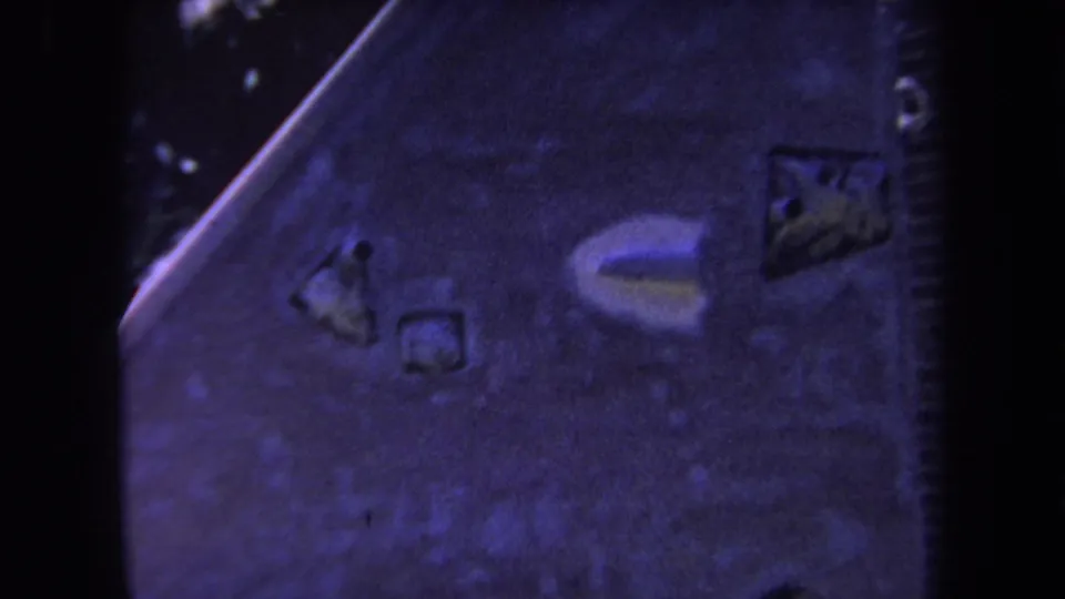 Close 8mm view of the wooden structure in Yucaipa, with purple-blue color shift and grain visible across the frame.