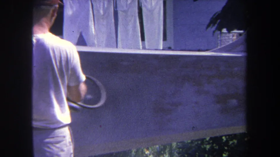The final frame shows the man beside the concrete structure, spray equipment in hand, with fence panels and greenery in the background.