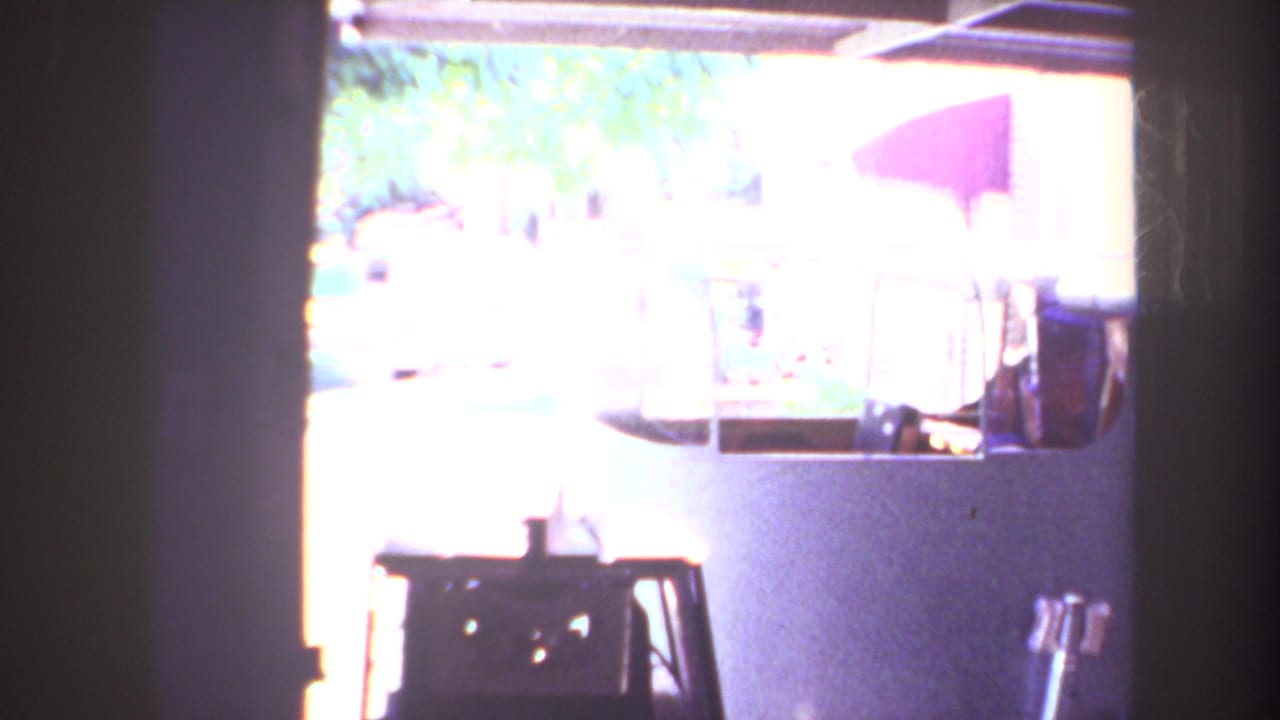 Overexposed garage view with part of a small aircraft and residential exterior visible beyond the opening.