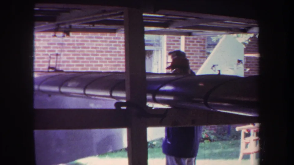 1969 Yucaipa backyard view through a window, with a person in dark clothing partly obscured by a large cylindrical form.