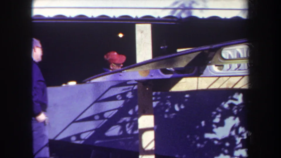 1969 Yucaipa fairground booth view with one adult man partly cropped in front and another in a red cap behind the counter.