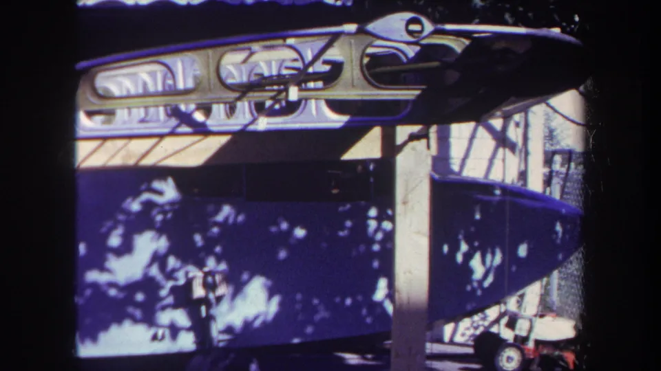 Close 8mm frame of a dark small boat or canoe side with metal supports and tree shadows in Yucaipa, California.
