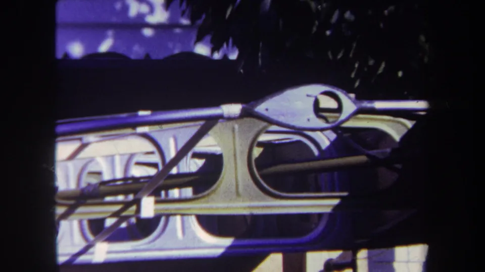Tight 1969 8mm view of metal framing and rigging on a small boat, with the dark hull partly visible behind.