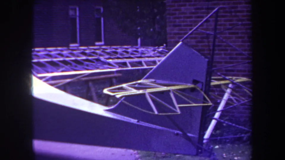 A close 1969 home-movie view of the model aircraft tail, with dark panels and yellow-trimmed metal rods.