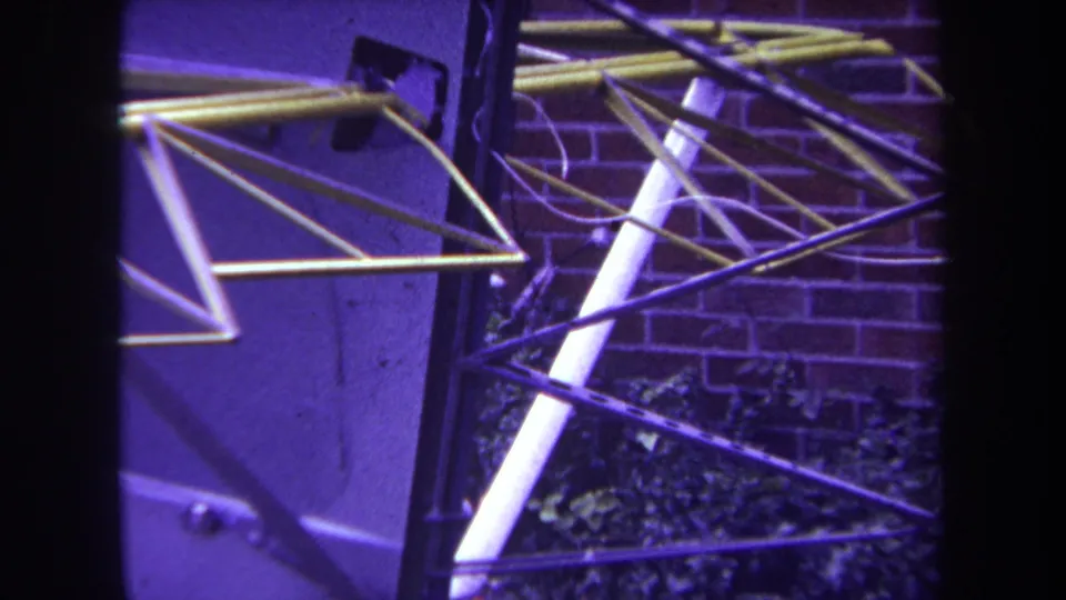 1969 Yucaipa frame with the aircraft's exposed truss and wing elements viewed close to a residential brick wall.