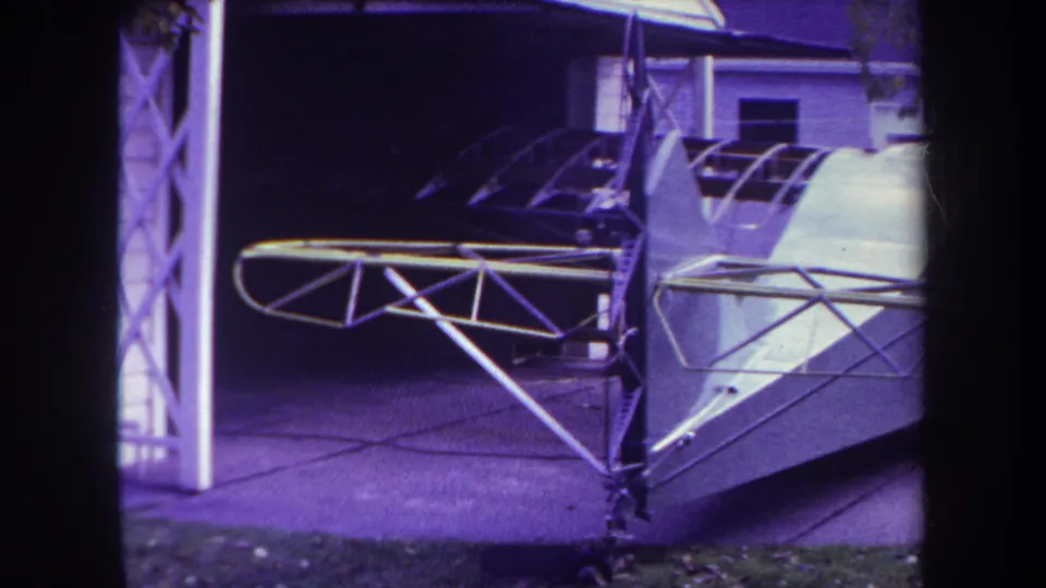 1969 Yucaipa frame showing the white fuselage, cockpit area, and exposed metal wing structure of a small aircraft in a driveway.