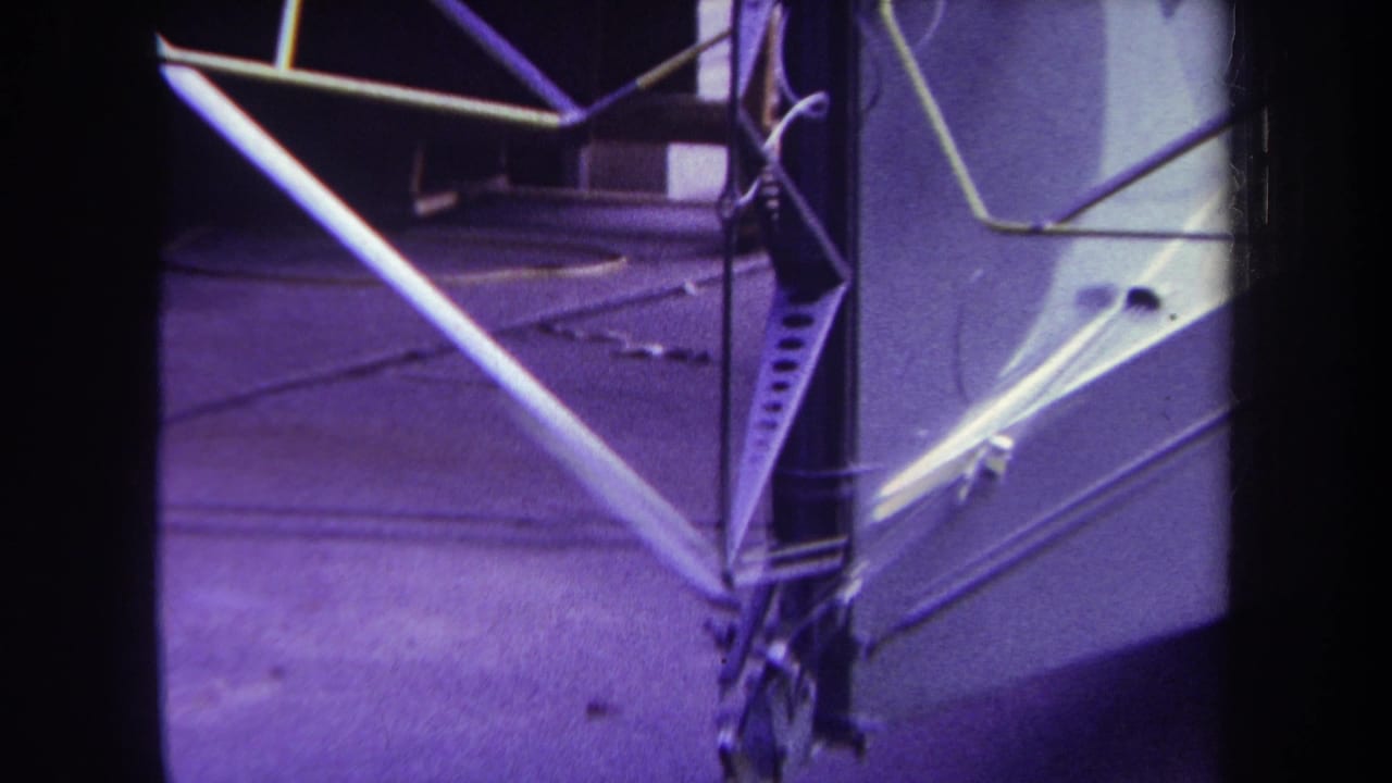 Close view of airplane tail framework with tubular braces and riveted metal panels.