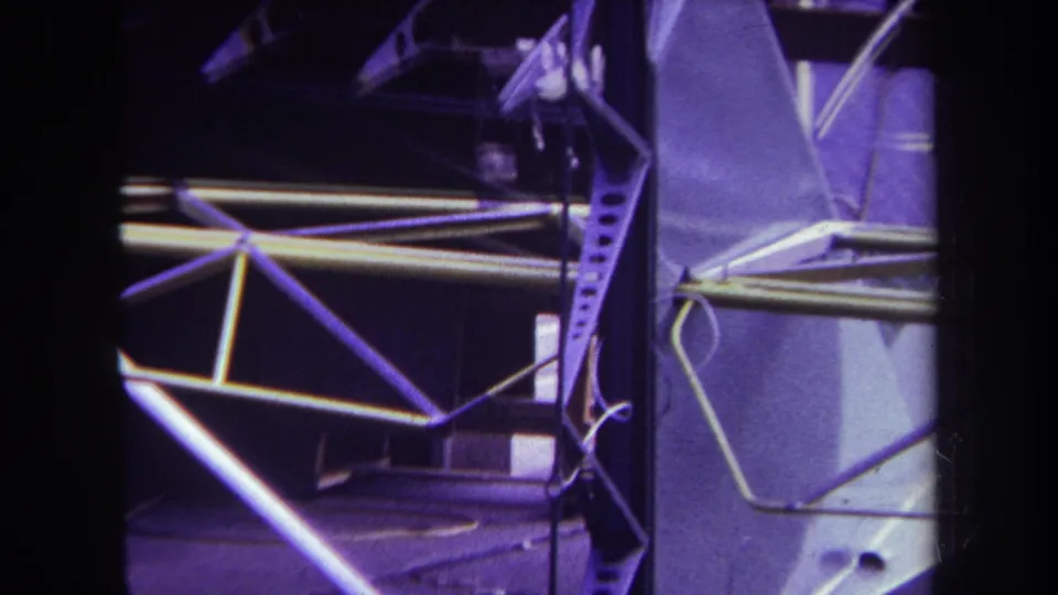 Close 1969 home-movie view of exposed aircraft tail supports and possible linkage near a metal panel in Volmer Yucaipa.