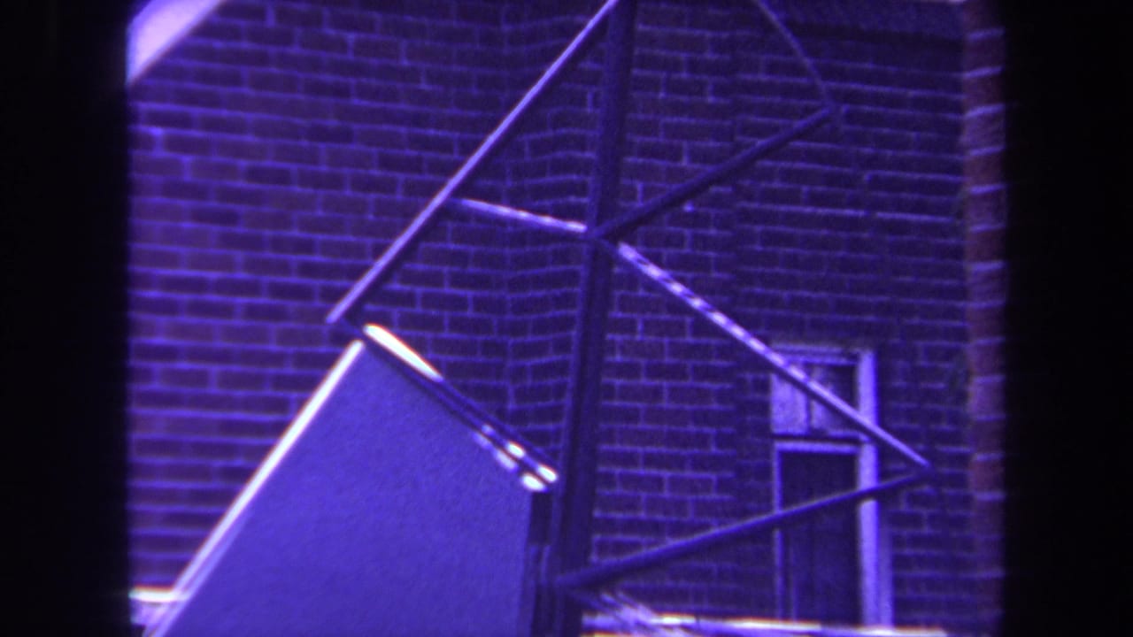 Close view of angular metal sculpture elements against brickwork.