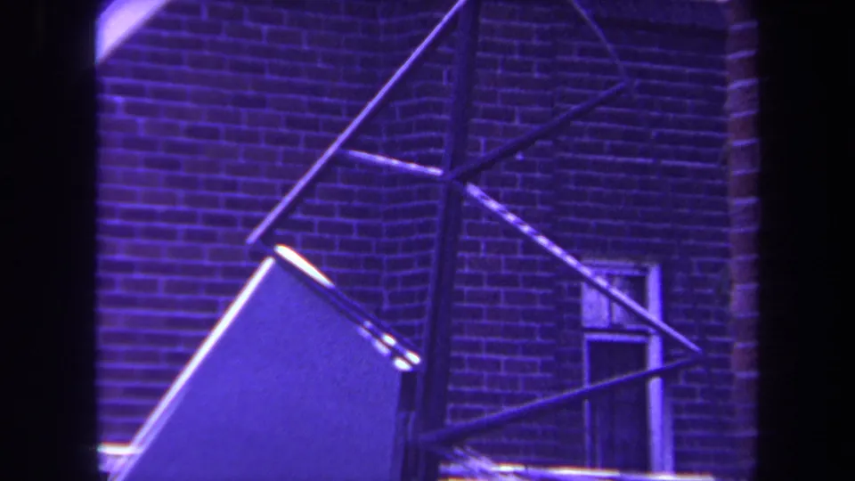 1969 Yucaipa frame with angular metal rods and a large flat panel set against a brick building exterior.