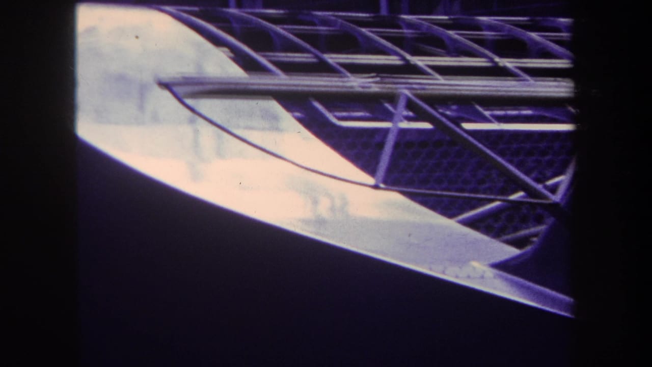1969 Yucaipa 8mm frame with a curved roof edge, metal support grid, and pale panel against a dark background.