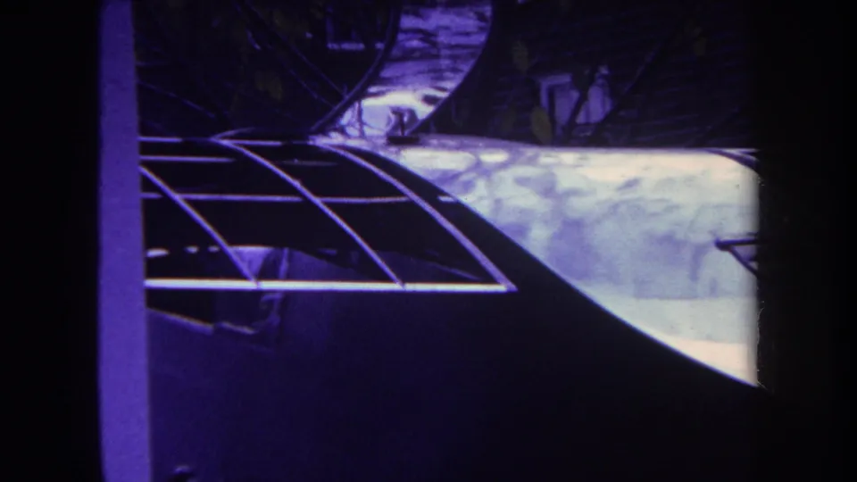 1969 Yucaipa 8mm frame showing shadowed roof framing and a pale panel in strong purple-yellow film color.