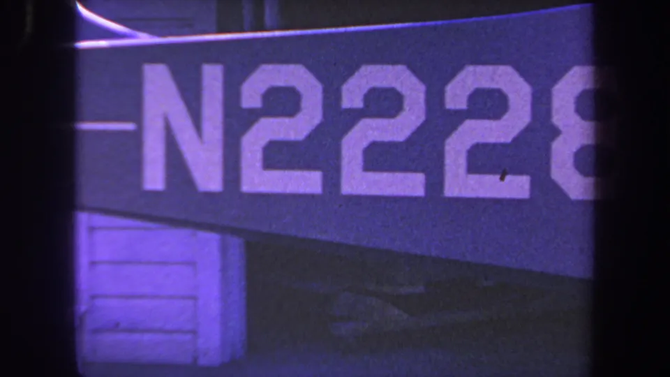 Frame showing the marked blue vehicle or aircraft surface with large white N2228 lettering in 1969 home-movie footage.