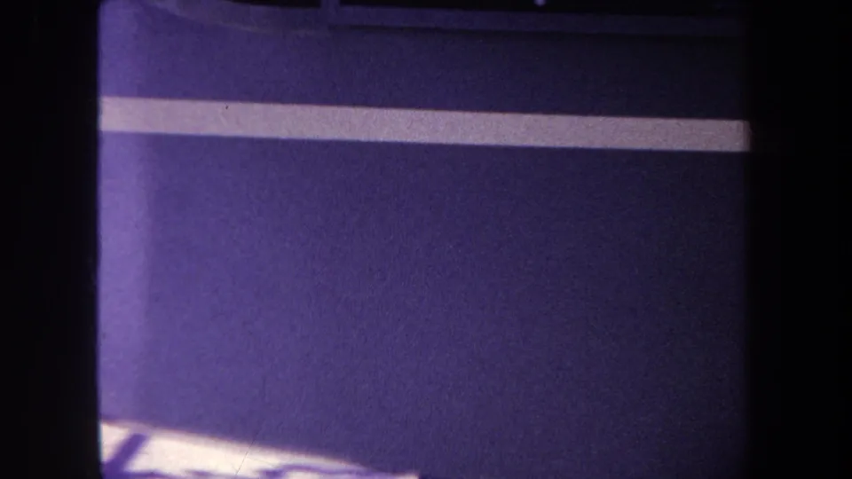 Close 8mm view of a purple panel and white stripe, with soft focus and heavy dark borders.