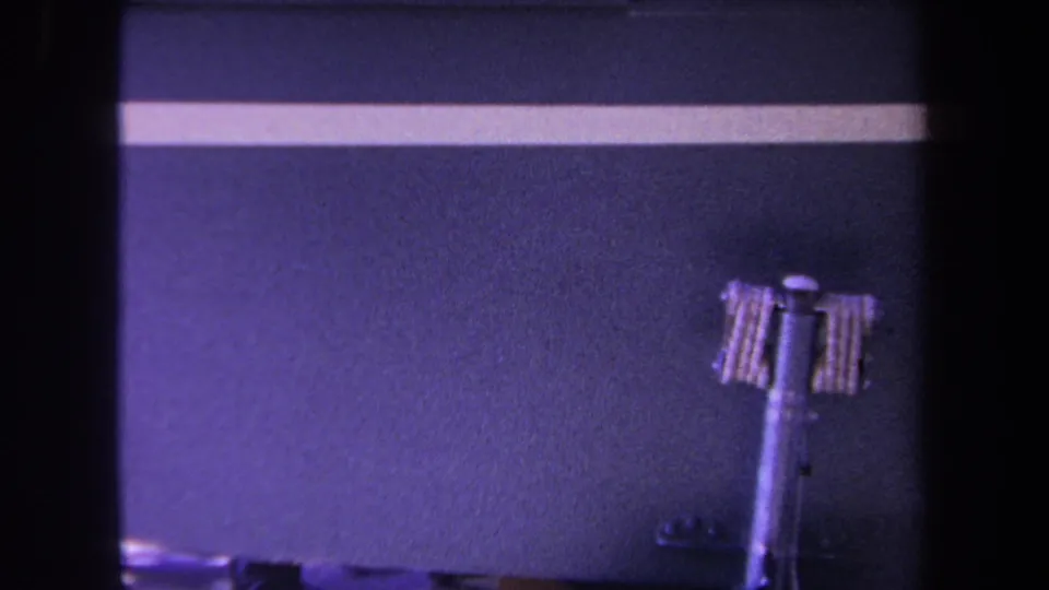 1969 Yucaipa 8mm frame showing a purple surface, white stripe, metal strut, and small wheel detail.