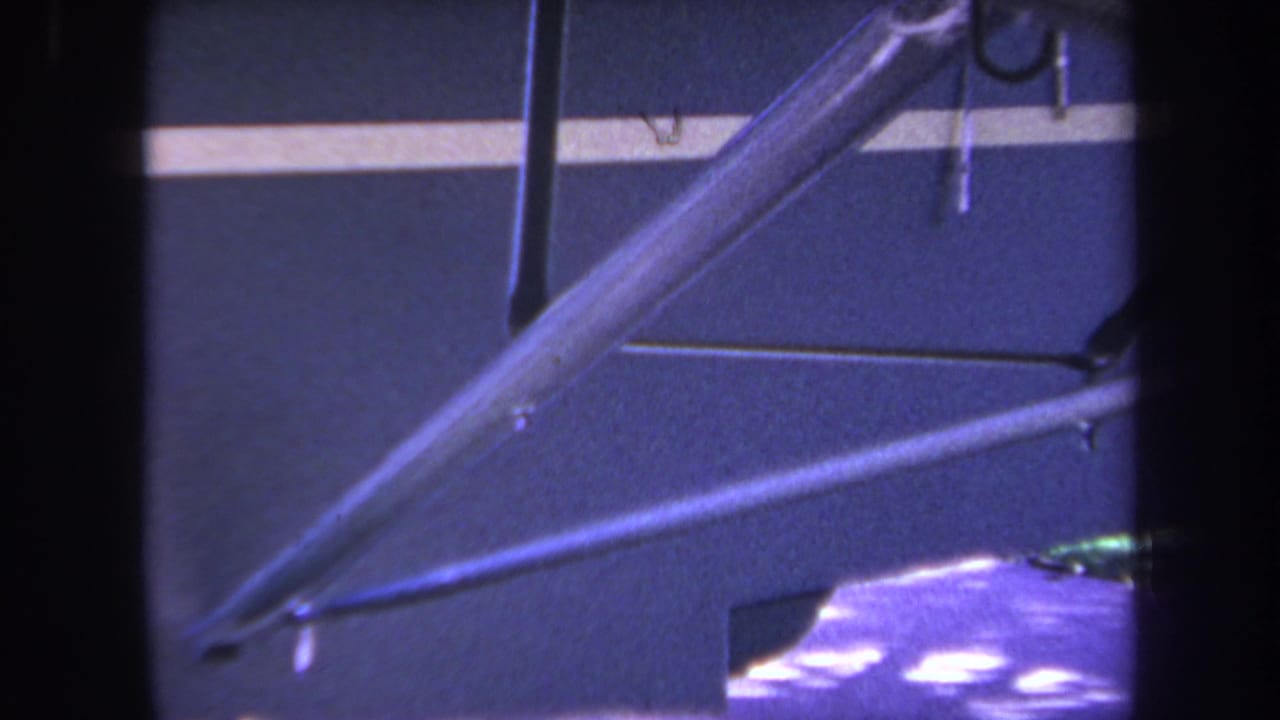 1969 Yucaipa home-movie frame showing a close view of small aircraft wing struts, fuselage paneling, and a pale stripe.