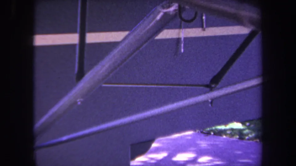 1969 home-movie frame from Yucaipa showing overlapping small-aircraft struts, fuselage surface, and a pale stripe.