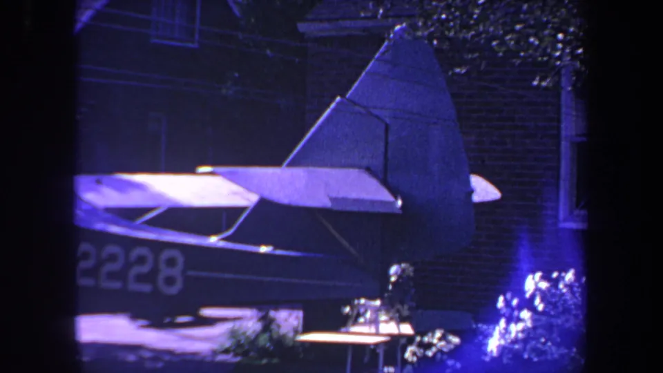 Small aircraft marked with a partial N2228 registration appears near a residential garage in 1969 Yucaipa footage.