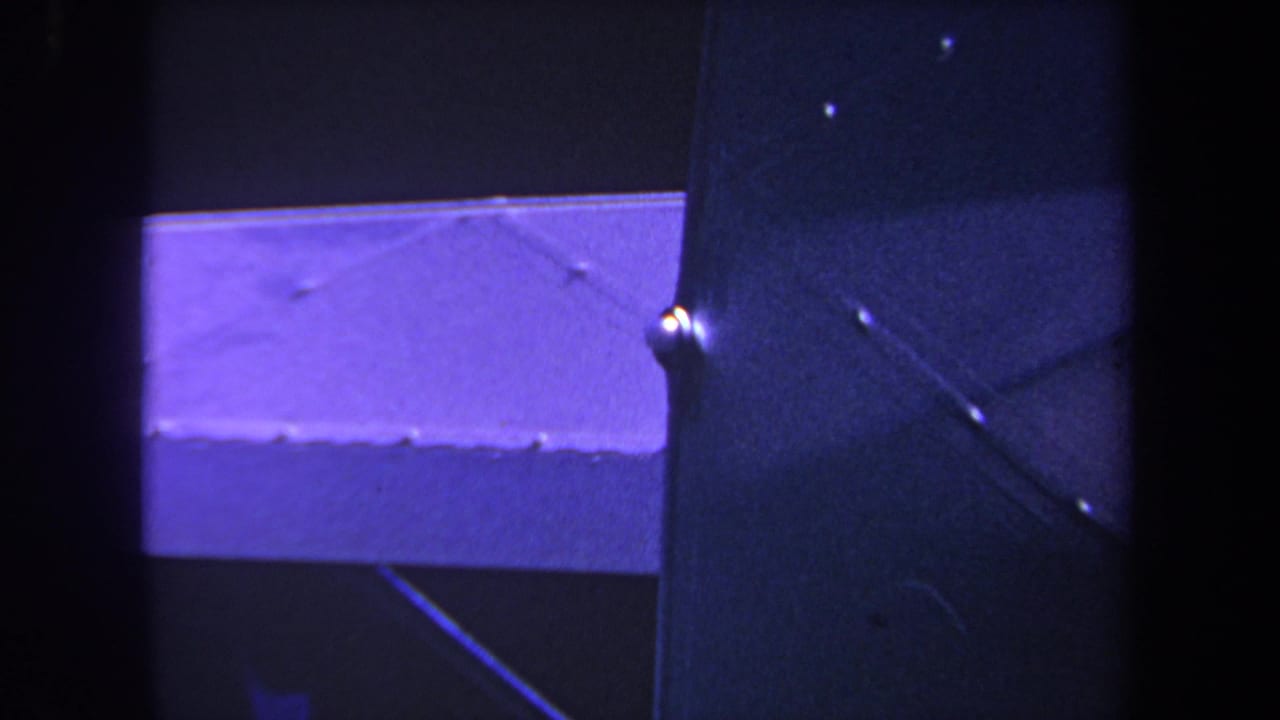 1969 8mm home-movie frame from Yucaipa, California, showing a close detail of an airplane wing, strut, and dark film borders.