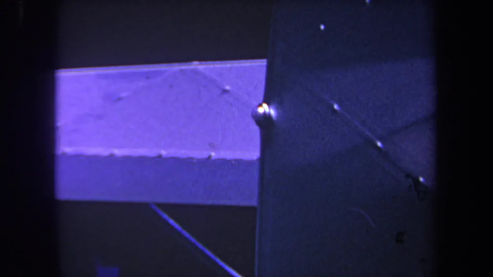 Close 1969 Yucaipa home-movie view of an airplane wing surface and strut, with pronounced purple cast and visible 8mm grain.
