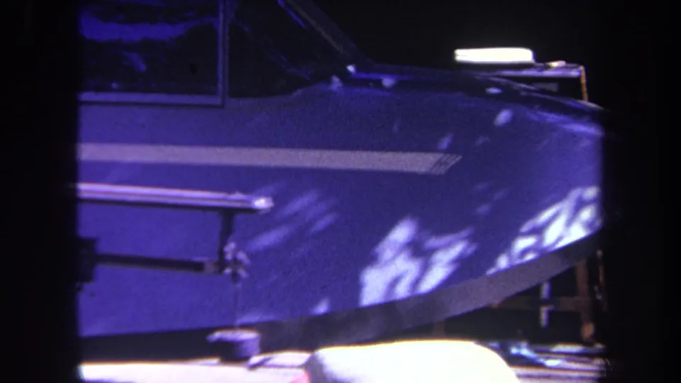 1969 home-movie frame from Yucaipa, California, showing the blue nose and cockpit area of a parked small airplane in bright sun.