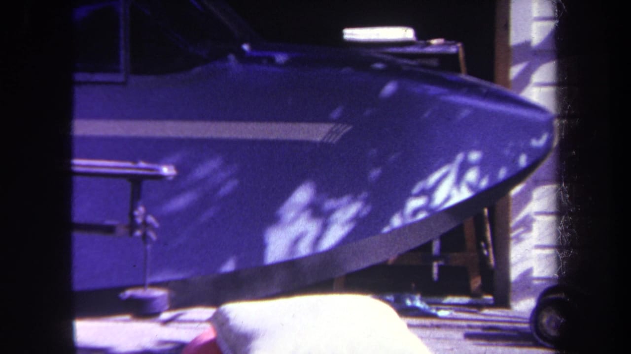 Blue airplane nose and cockpit area with white stripe and strong sunlight.