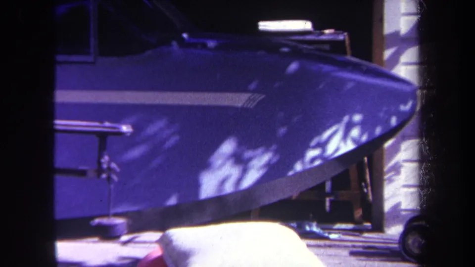 Blue small aircraft nose and cockpit area, filmed close-up in 1969 Yucaipa home-movie footage with bright reflections on the body.