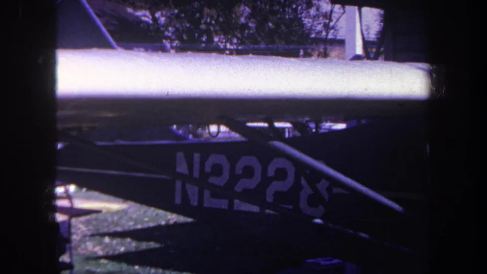 1969 Yucaipa frame showing the lower portion of a blue airplane, including a wing or support surface and partial registration number.