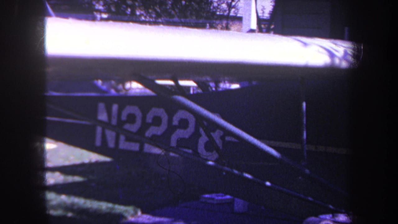 Close view of a blue aircraft fuselage with partial N2228 registration and struts.