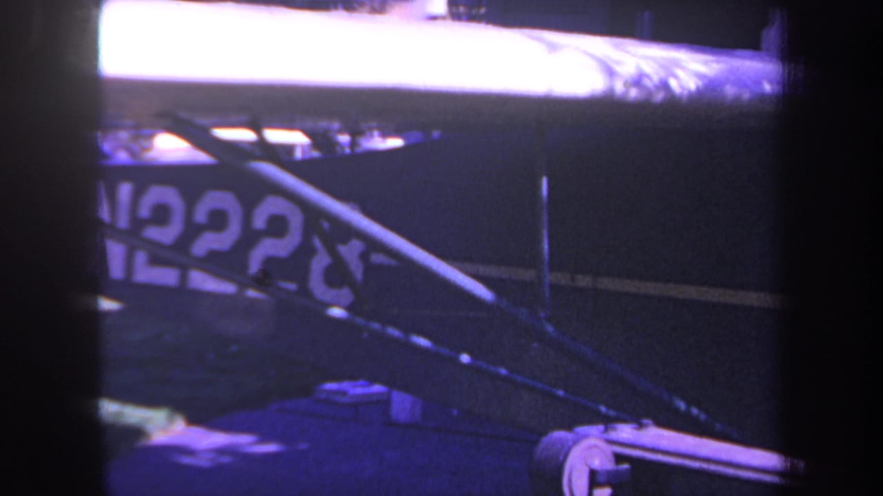 Close 1969 home-movie view of the blue aircraft side, with N2228 registration partly obscured by diagonal struts.