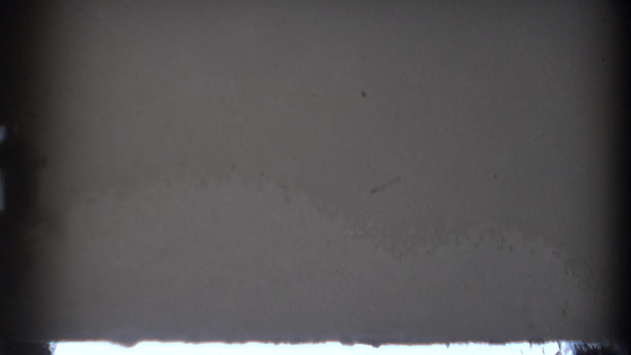 Dark film leader or obstructed frame with a thin bright strip near the lower edge.