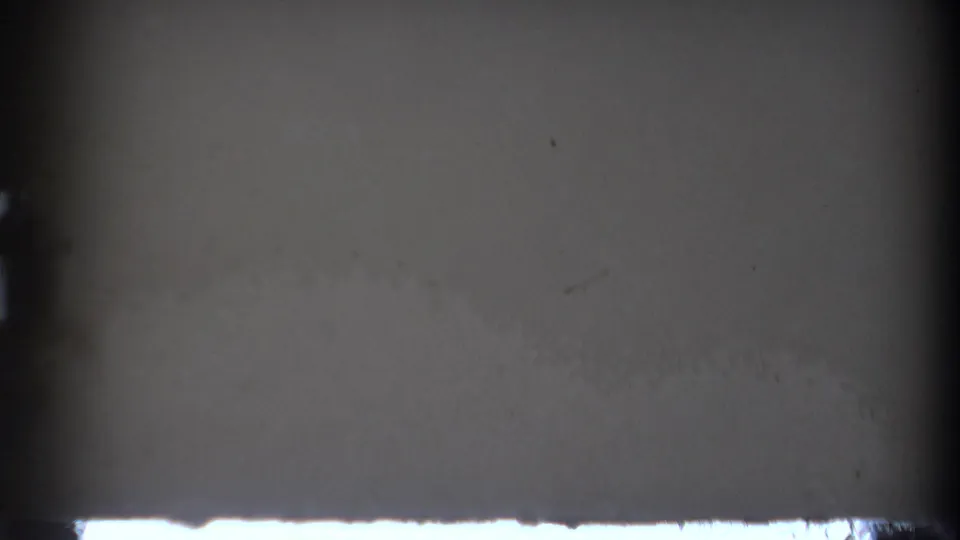 Mostly dark or obstructed 8mm frame with a light band along the bottom edge before the Hong Kong traffic view appears.