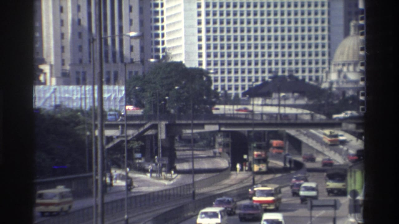 Traffic moves along layered Hong Kong roadways beneath tall buildings.
