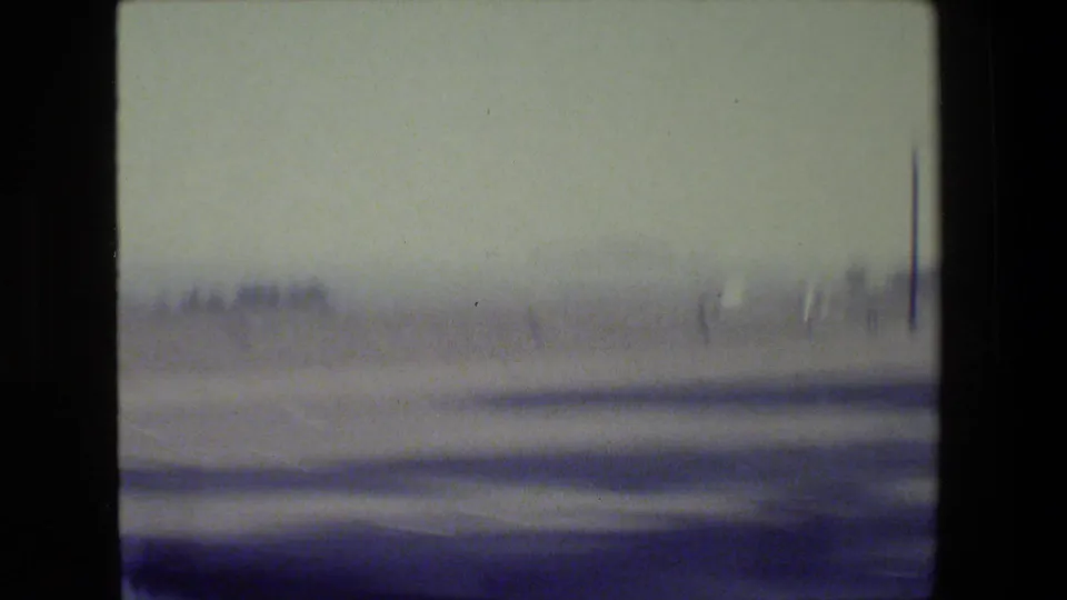 Soft, motion-blurred 1984 San Francisco-area road view with a low horizon, pale sky, and dark film-frame borders.