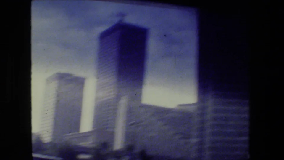 Soft 1980s San Francisco high-rise view with tall office buildings, strong motion blur, faded color, and visible film edges.