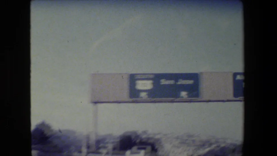 1984 California highway view showing an overhead Route 101 South San Jose sign and blurred traffic below.
