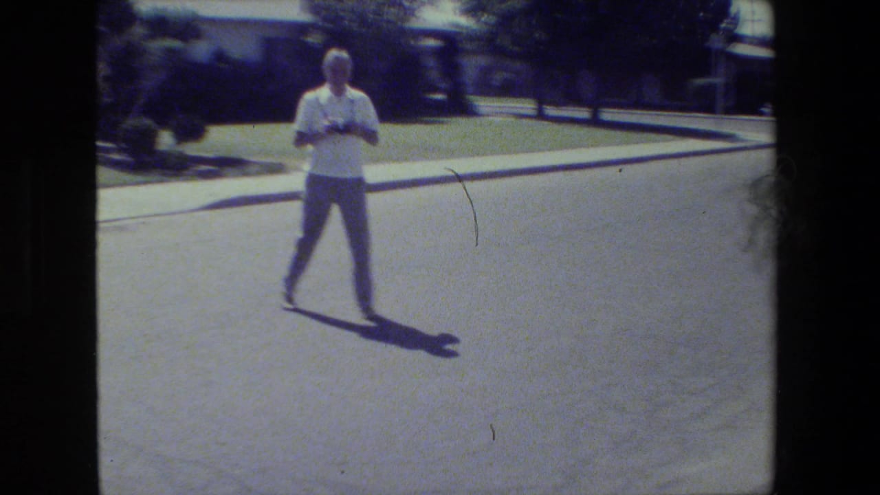 In 1984 San Francisco home-movie footage, an older man stands on a residential street with a camera in his hands.