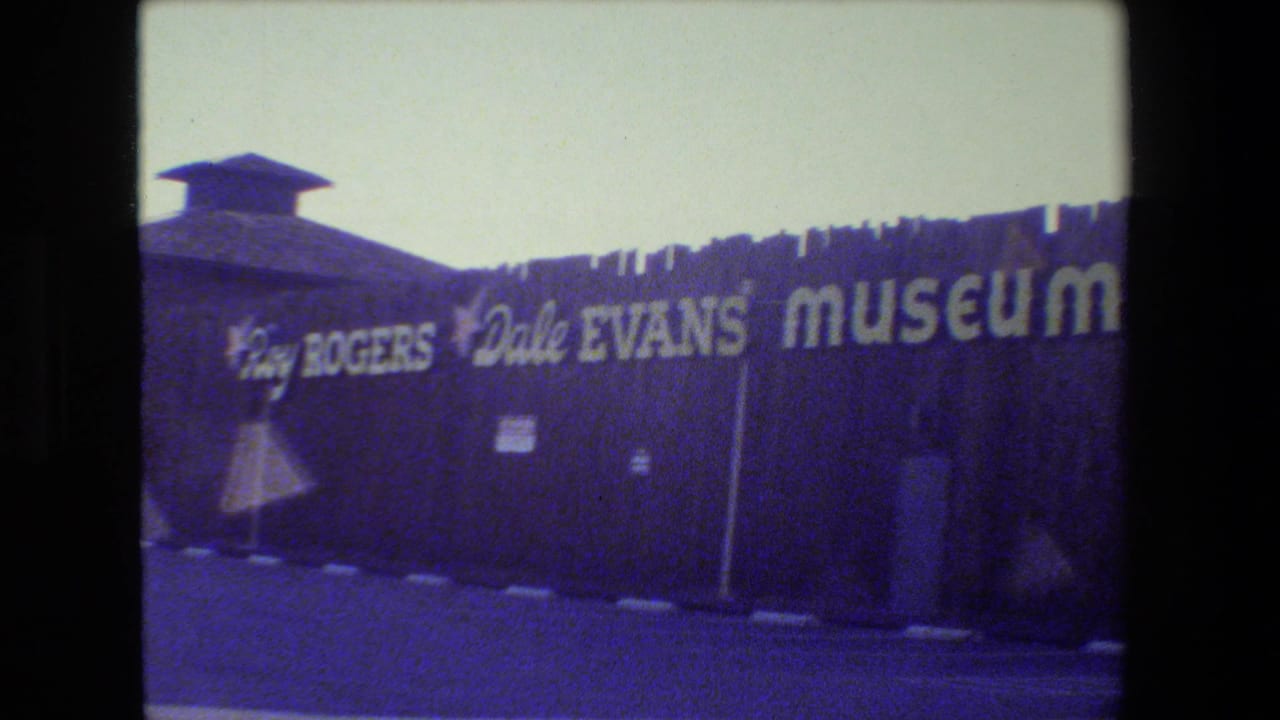 1984 8mm frame showing the Roy Rogers Dale Evans Museum facade in California with bold white lettering on a dark exterior wall.