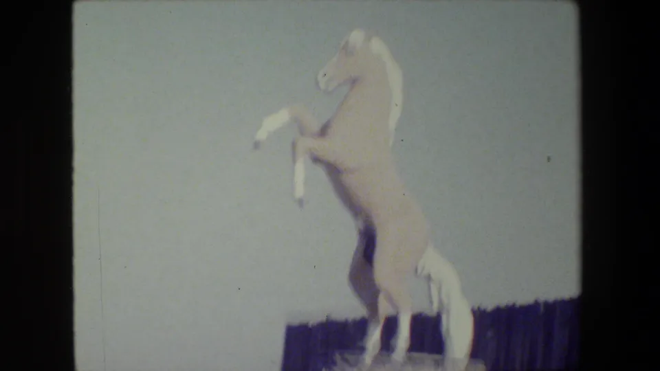 Close 1984 San Francisco frame showing the white rearing horse statue against a pale sky with a dark fence below.