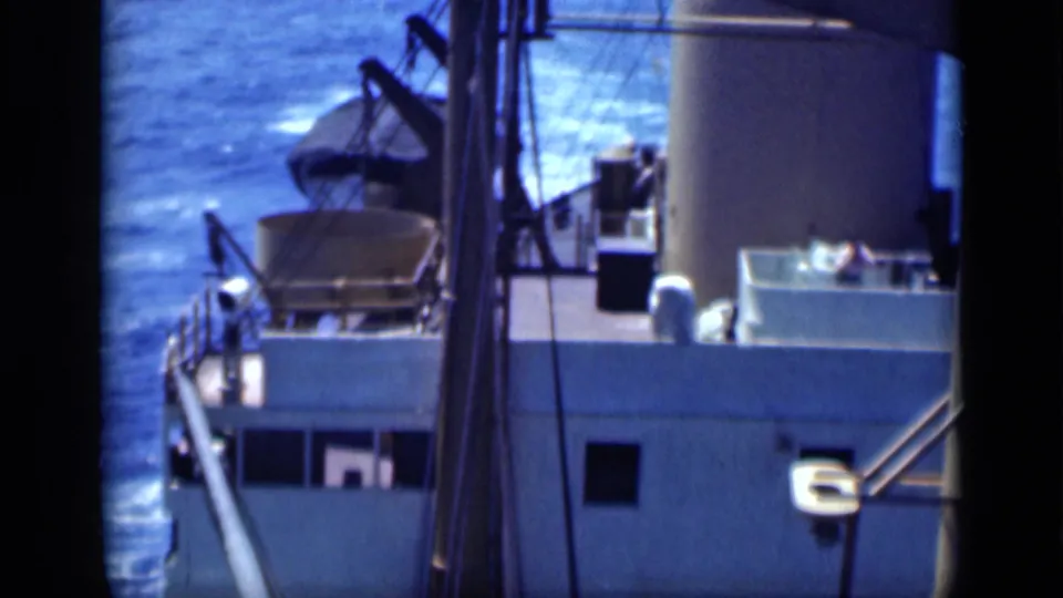 1946 Cairo, Egypt reel frame showing a large ship deck at sea, with a funnel, railings, rigging, and small crew figures visible.