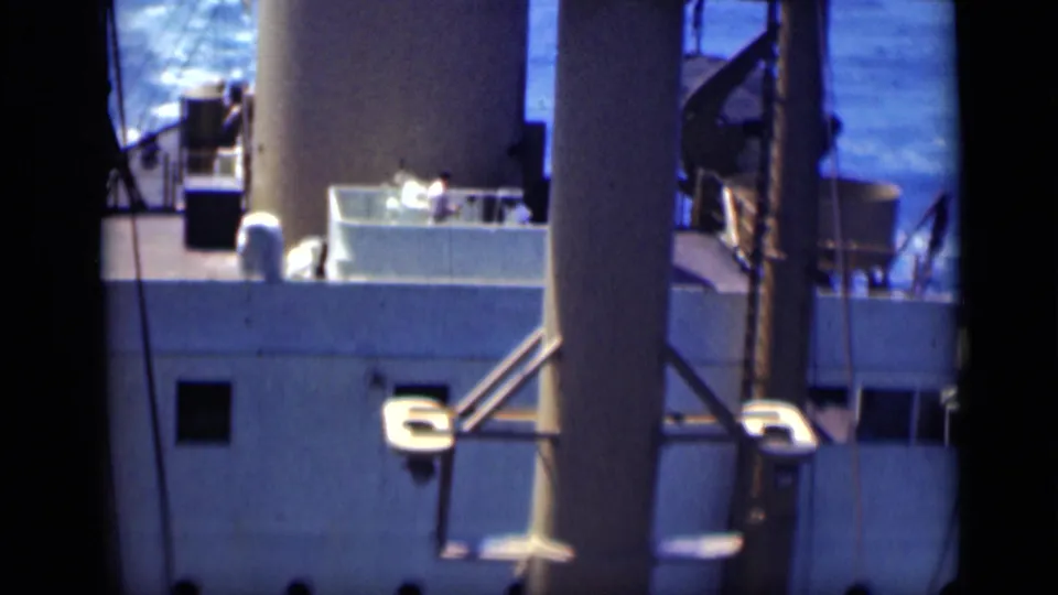 1946 Egypt 8mm frame showing the side of a large ship with deck structures, railings and water visible behind it.