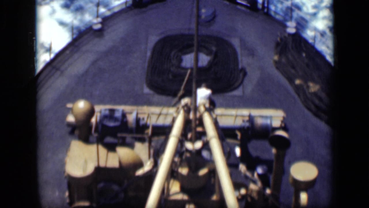 1940s 8mm frame of ship deck machinery, rope, barrels, and surrounding sea from a high handheld angle.