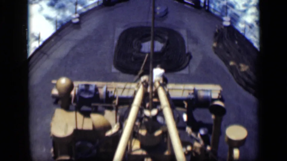1940s 8mm frame of ship deck machinery, rope, barrels, and surrounding sea from a high handheld angle.