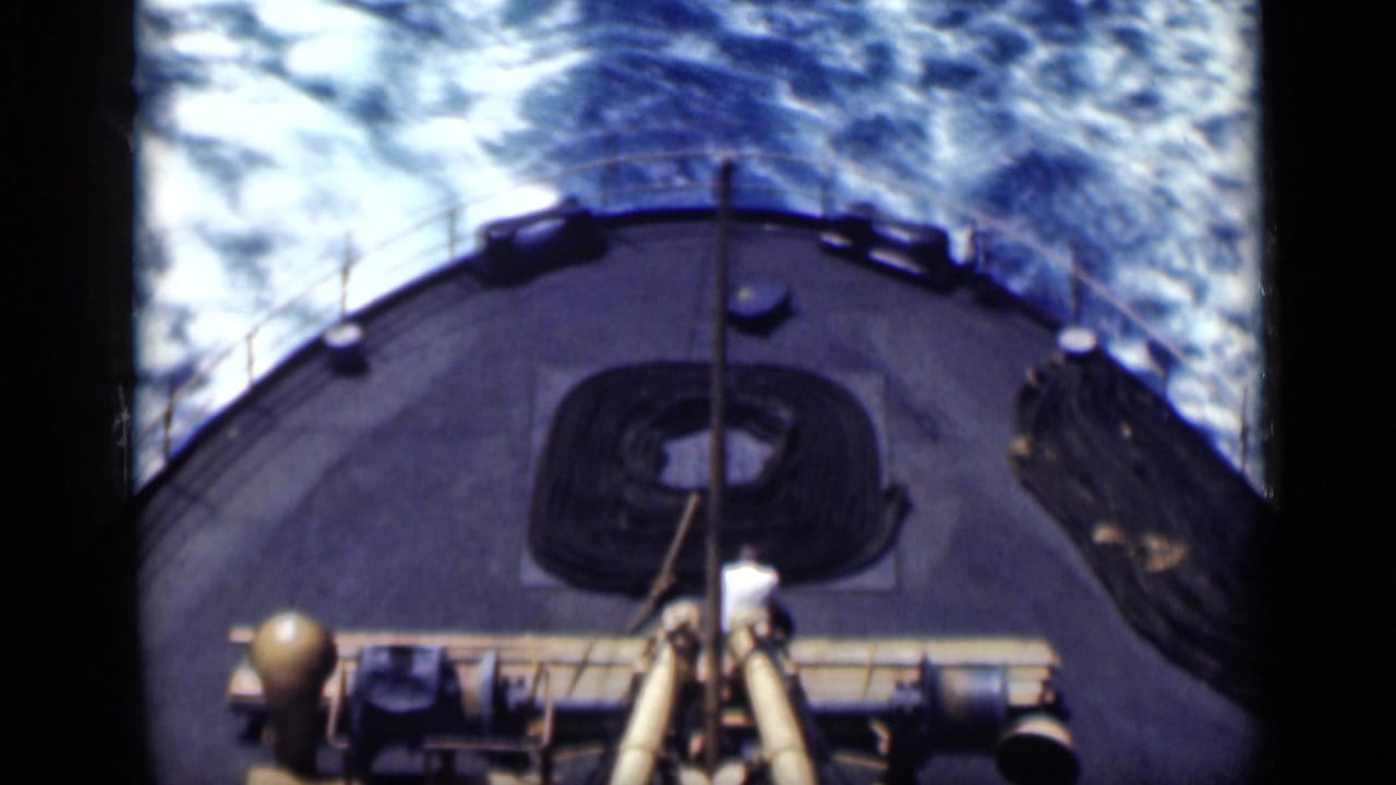 1946 shipboard home-movie frame looking over stern deck equipment toward the wake in blue water.