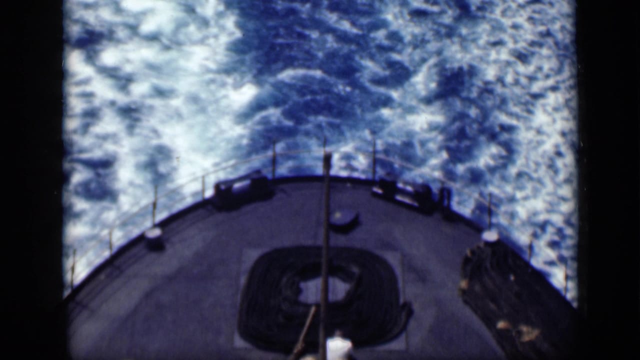 1946 Cairo, Egypt reel frame showing a ship stern from above as blue water and white wake trail behind the vessel.