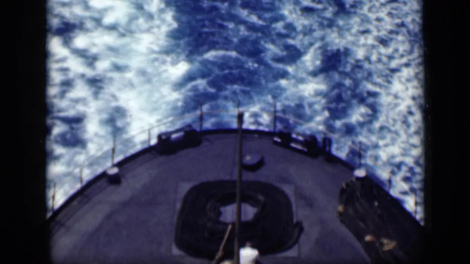 1946 Cairo, Egypt reel frame showing a ship stern from above as blue water and white wake trail behind the vessel.