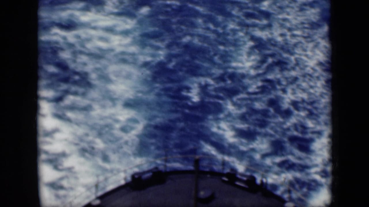 Archival 8mm frame from the 1946 Cairo, Egypt reel showing the ship's stern edge and foaming wake across deep blue water.