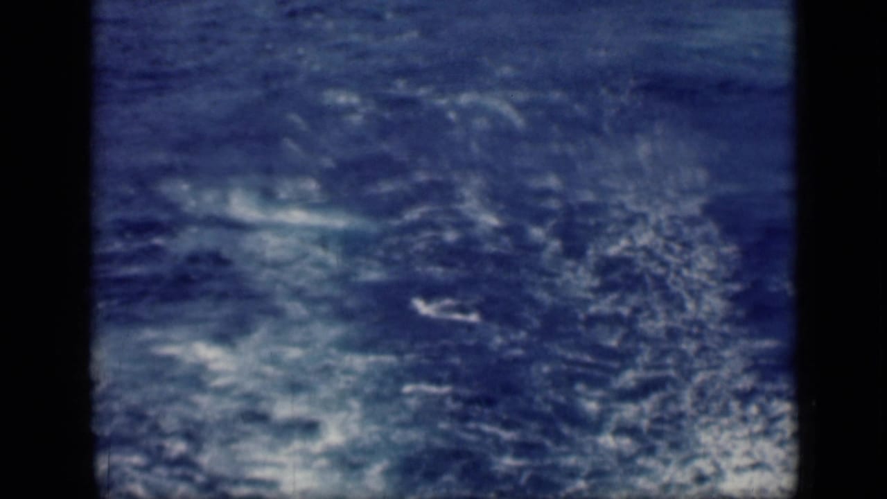 Archival 8mm frame from the 1946 Cairo, Egypt reel showing mostly open blue water with turbulent white wake and visible film softness.