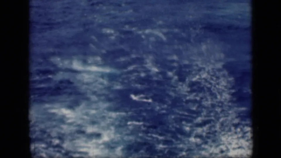 Archival 8mm frame from the 1946 Cairo, Egypt reel showing mostly open blue water with turbulent white wake and visible film softness.